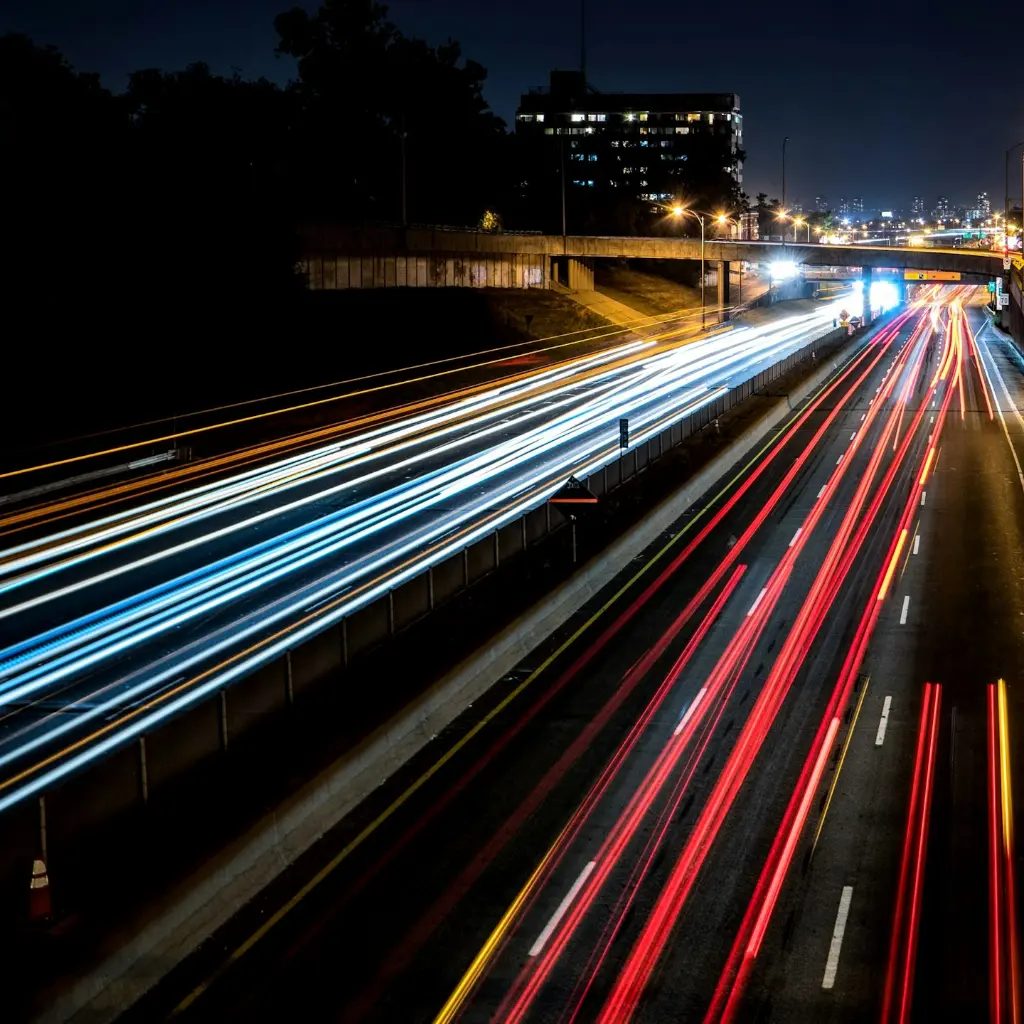 time-lapse photography of cars passing through the road during night time