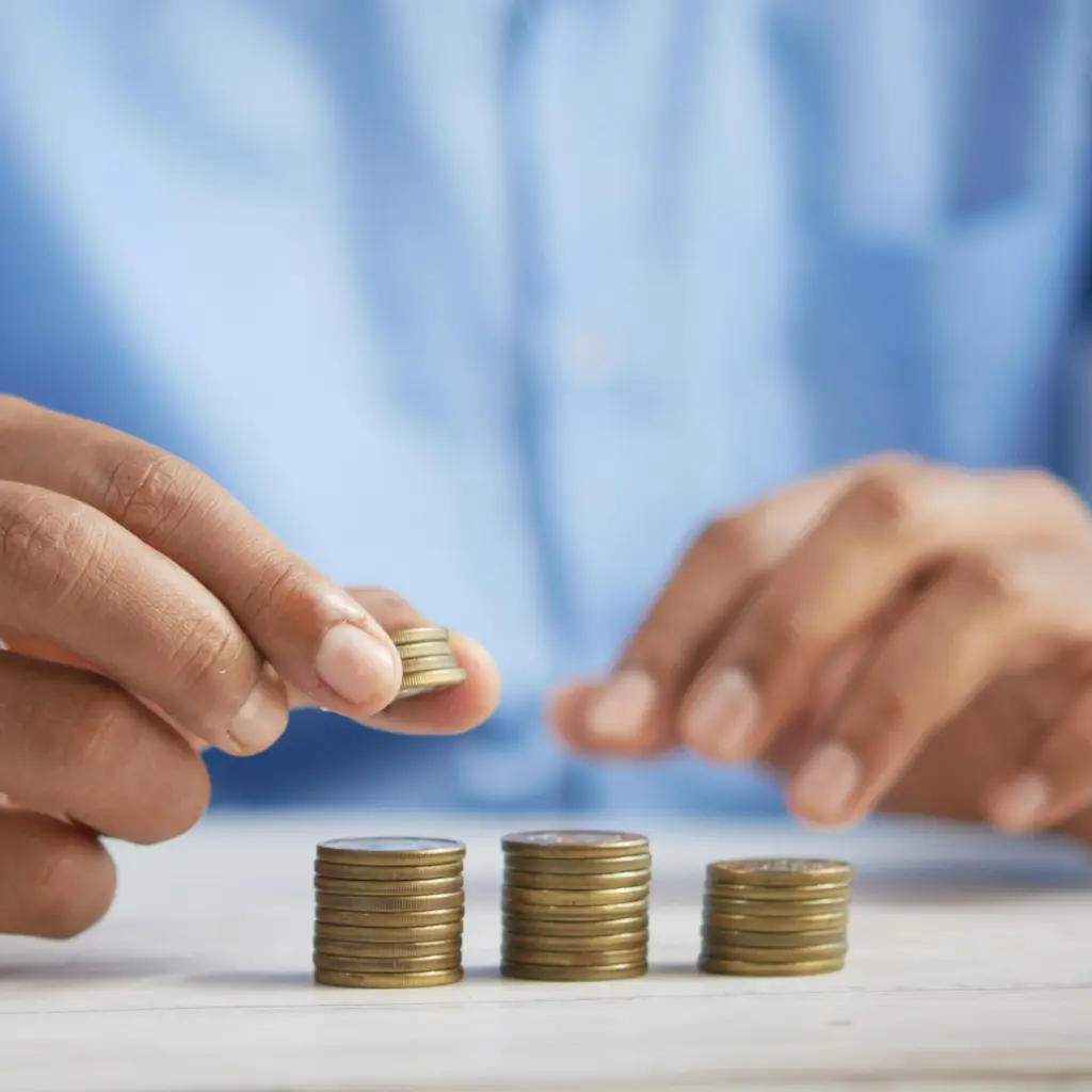 a person stacking coins on top of a table